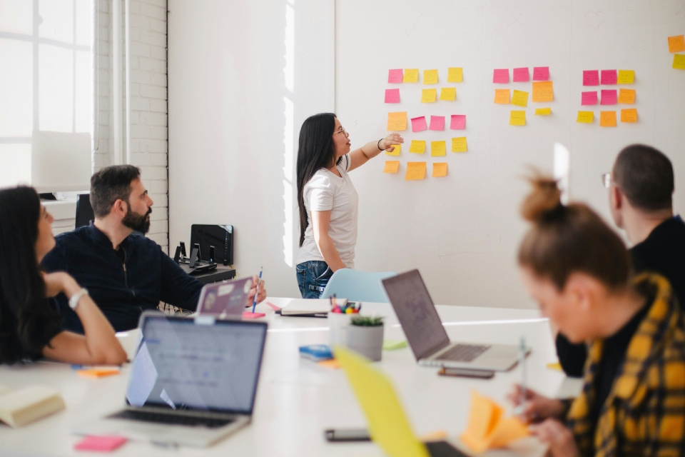 Woman leading team brainstorming session with sticky notes